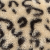 Close-up of a beige-black leopard pattern on soft fur material.