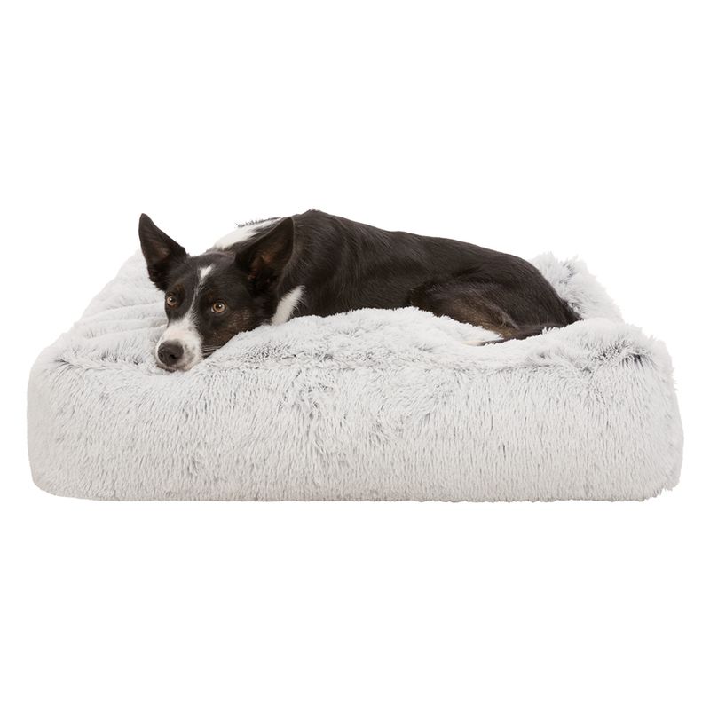 Dog lying on a grey, fluffy pet bed. Product shows comfort and design of the bed.
