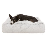 Dog lying on a grey, fluffy pet bed. Product shows comfort and design of the bed.