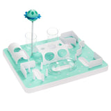 Toy set with green base, white obstacles and transparent tubes. Includes a feather with a blue-green ball on top.