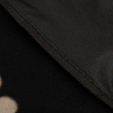 Close-up of a black dog blanket with non-slip underside and paw pattern on the top side.