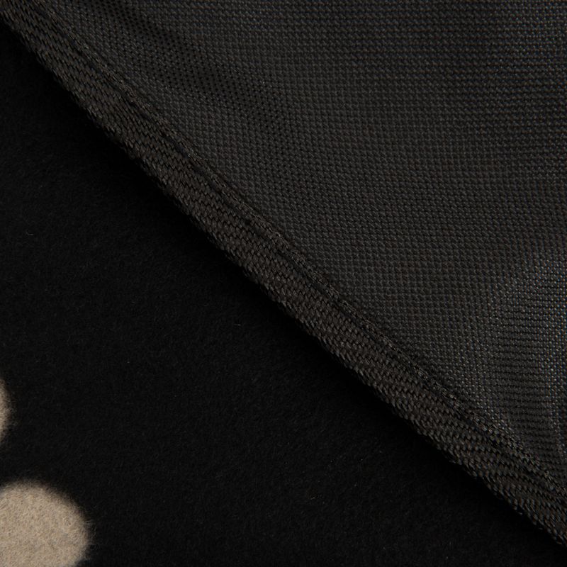 Close-up of a black dog blanket with non-slip underside and paw pattern on the top side.