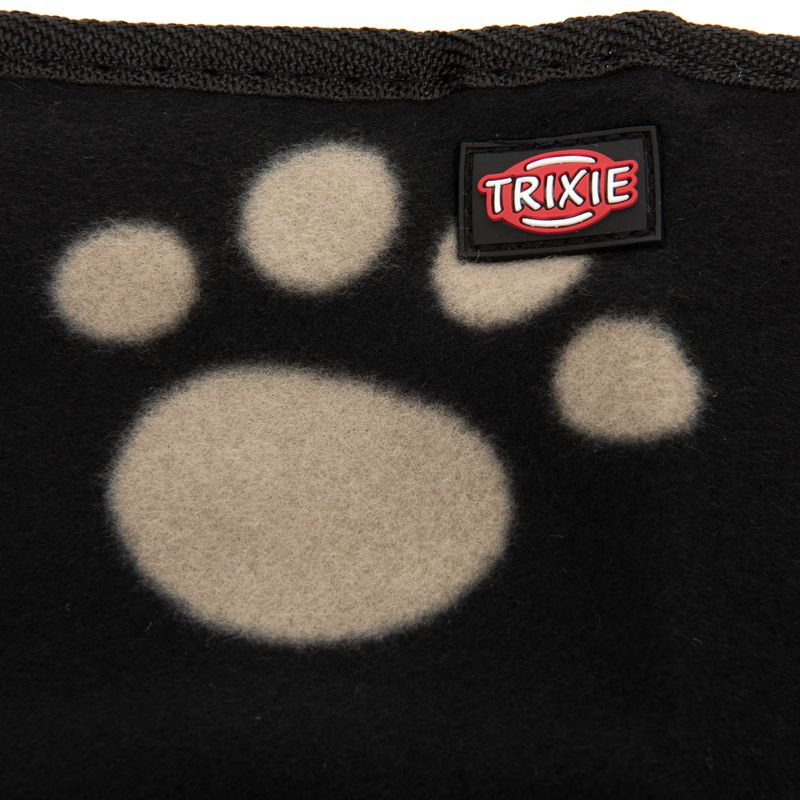 Trixie logo on black fabric with beige paw print pattern.