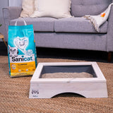 Sanicat Clumping cat litter, 10L, unscented, with oxygen control. Shown next to a wooden cat toilet with grey insert.