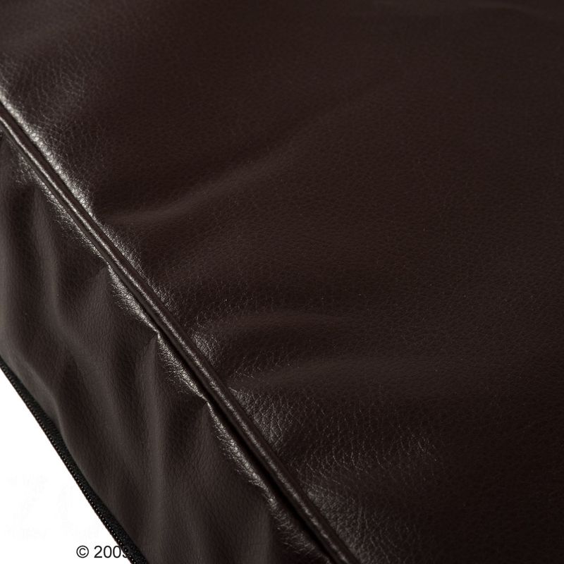 Close-up of a brown faux leather surface with visible seams and texture.