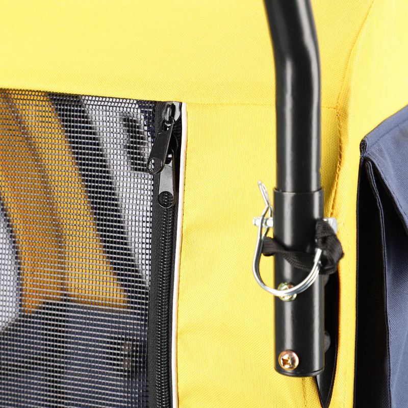 Close-up of a yellow transport trolley with mesh window, zip and black metal frame with safety hooks.