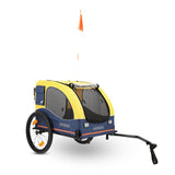 Yellow and blue bicycle trailer for pets with mesh windows, orange safety flag, and 'Hafenbande' printed on both sides.