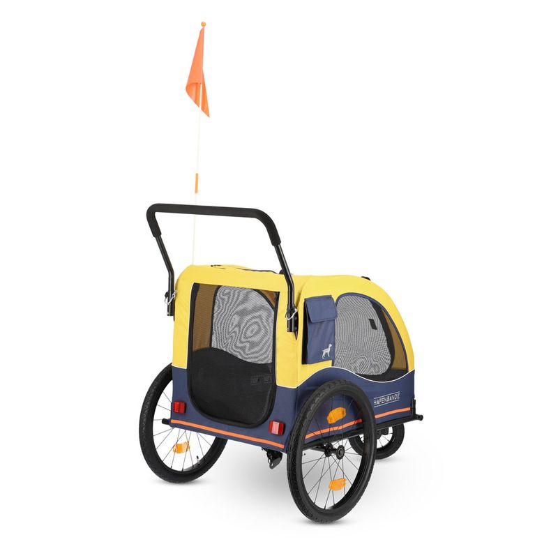 Yellow and blue bicycle trailer with mesh windows, two large wheels, handle and orange flag. Side inscription 'Hafenbanane'.