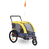 Yellow and blue dog trailer with three wheels, mesh windows, orange safety flag and the inscription 'Hafenbande'.