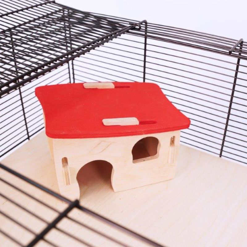 Wooden small animal house with red roof placed inside a wire cage, showing two arched entrances and one window opening.