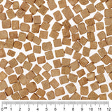 Close-up of brown, square dry food pieces with a centimetre scale at the bottom edge of the image.