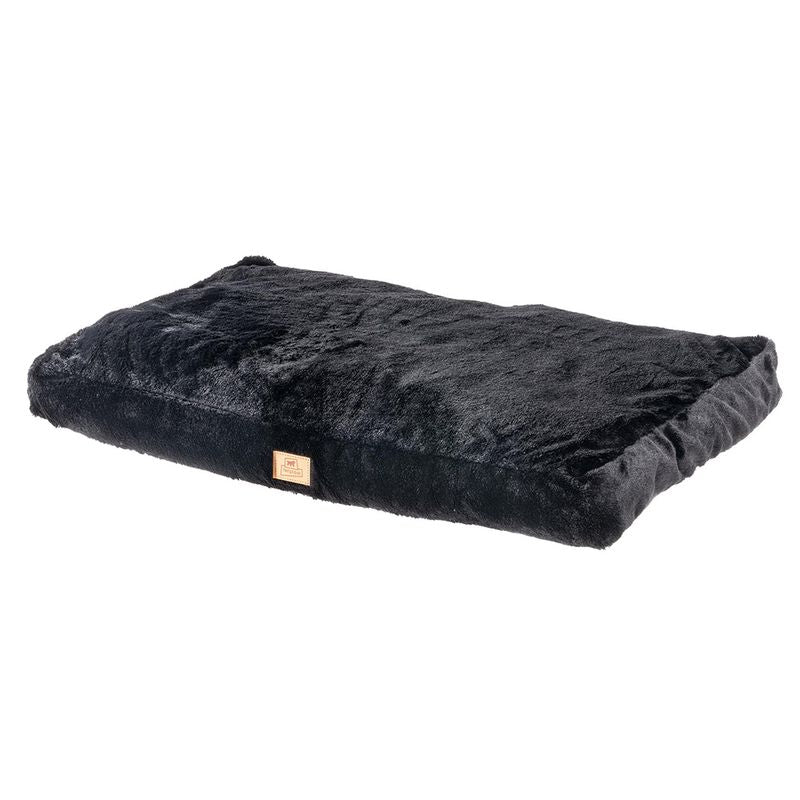 Black rectangular cushion with soft plush surface and a small brown label on the side.