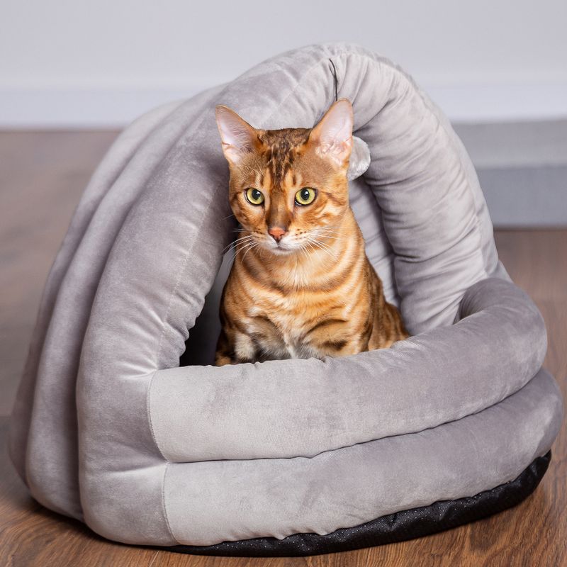 Grey, soft pet bed in spiral shape with a cat inside. Suitable as a cosy retreat for pets.