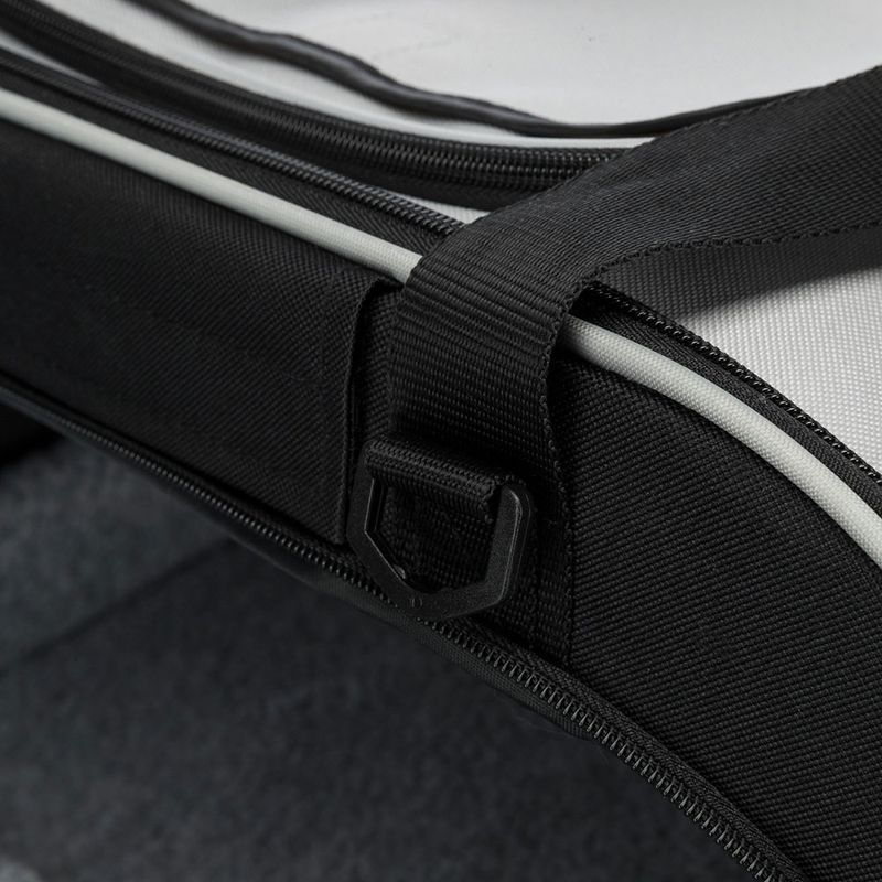 Close-up of a black strap with D-ring and zip on a product, possibly a bag or carrier.