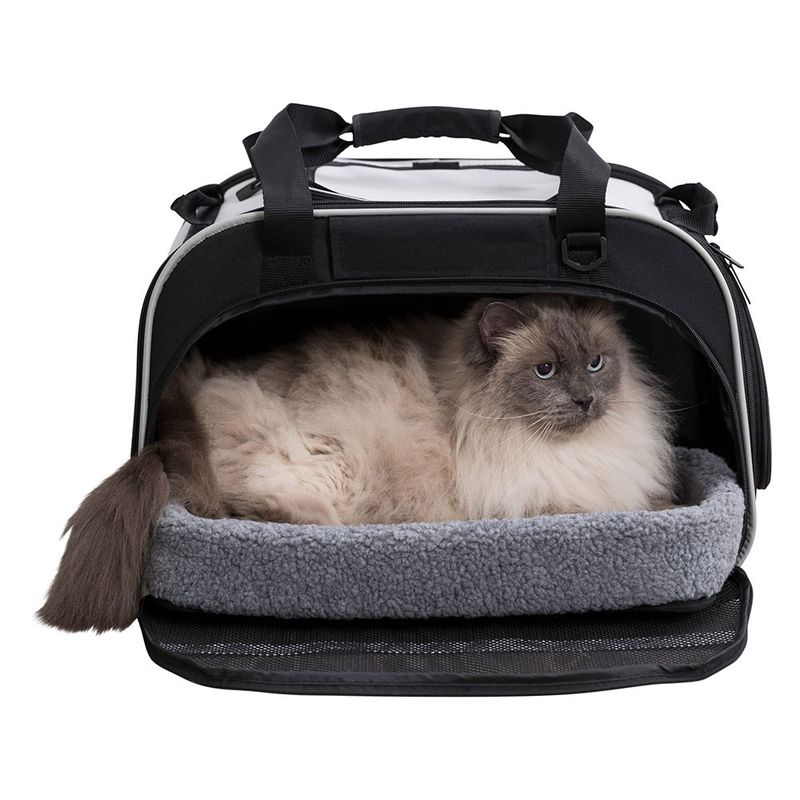 Transport bag with soft grey lying surface and a cat inside. Bag with carrying handles and zip opening.