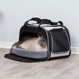Transport bag with grey inner padding, mesh window and carrying handles. Cat lying relaxed inside the bag.