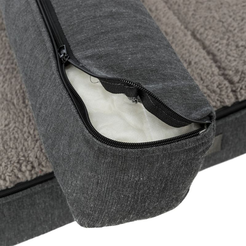 Close-up of a grey dog bed with removable cover and zip, showing inner padding.
