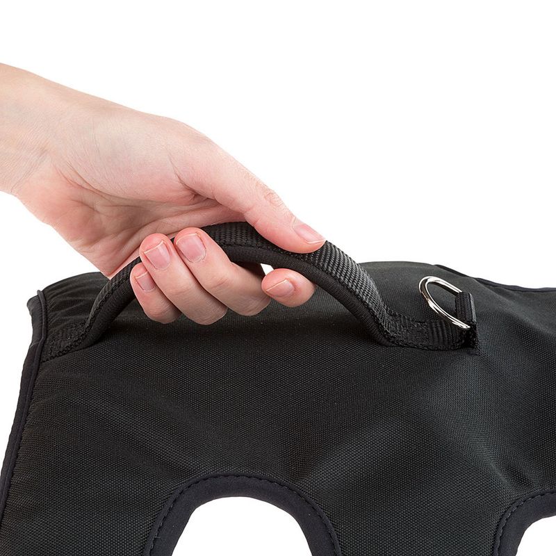 Hand holding a black nylon handle with metal ring, attached to black fabric material. Close-up of a product.
