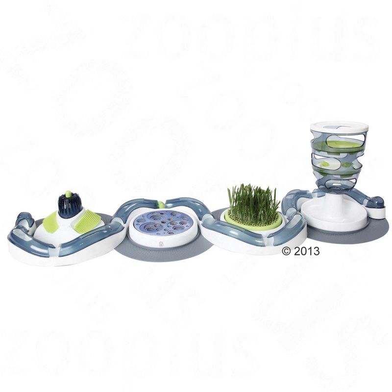 Interactive toy with multiple stations: brush, food dispenser, grass area and puzzle elements. Encourages activity and engagement.