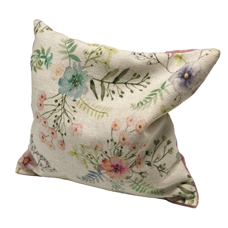 Decorative cushion with floral pattern in pastel colours, including flowers and leaves on beige fabric.