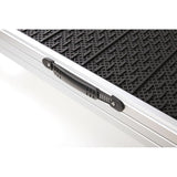 Close-up view of an aluminium ramp with non-slip black surface and carrying handle.