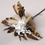 Toy with brown and white feathers and white paper strips, attached to a black chain.