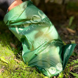 Green bag with 'kooa The Pet Care' print and symbols for dog, waste disposal and recycling.