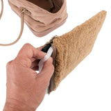 Hand showing removable inner padding from a beige bag with zip and plush material.