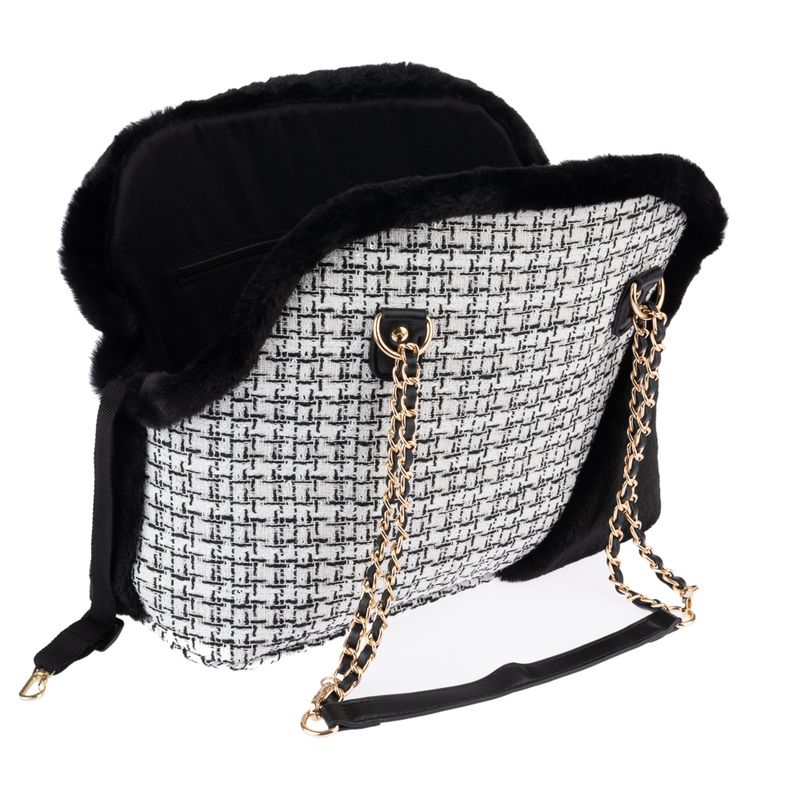 Transport bag with black and white pattern, gold chains as carrying handle and black faux fur trim. Inner compartment visible.