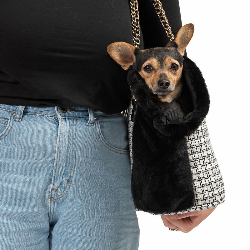 Carrier bag with black and white pattern and black plush lining, suitable for small pets. Gold chains visible as carrying handle.