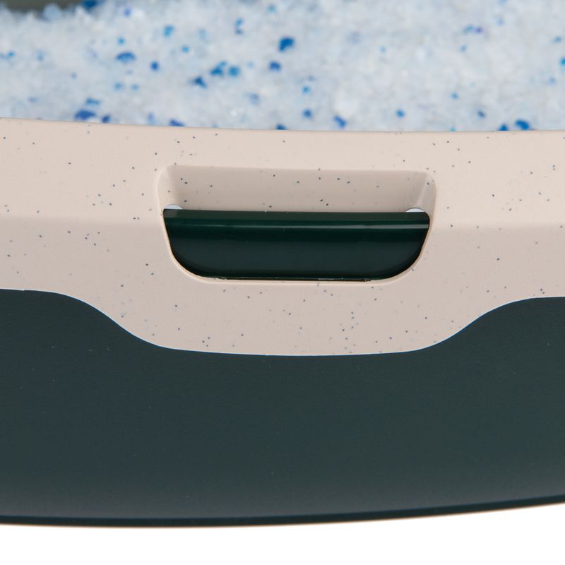 Close-up of a container with blue and white granule crystals, suitable for cat litter or similar uses.
