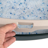 Hand holding the handle of a cat litter box with blue and white silica litter.