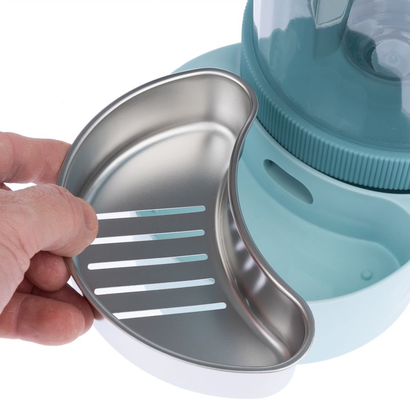 Hand holding a removable stainless steel insert with slots, suitable for a blue food or water dispenser.
