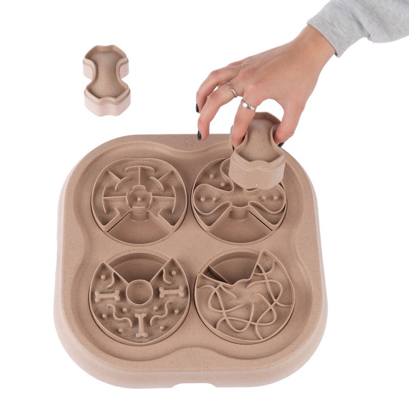 Interactive toy with four compartments and removable elements, hand demonstrating use by removing a part.