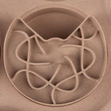 Round feeding maze made of beige plastic with cat head design and winding tracks for slow feeding.