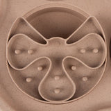 Close-up of a beige anti-gulping bowl with multiple indentations and elevations for slow food intake.