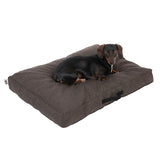 Dog lying on a brown rectangular dog cushion with carrying handle. Cushion features padded surface and robust design.