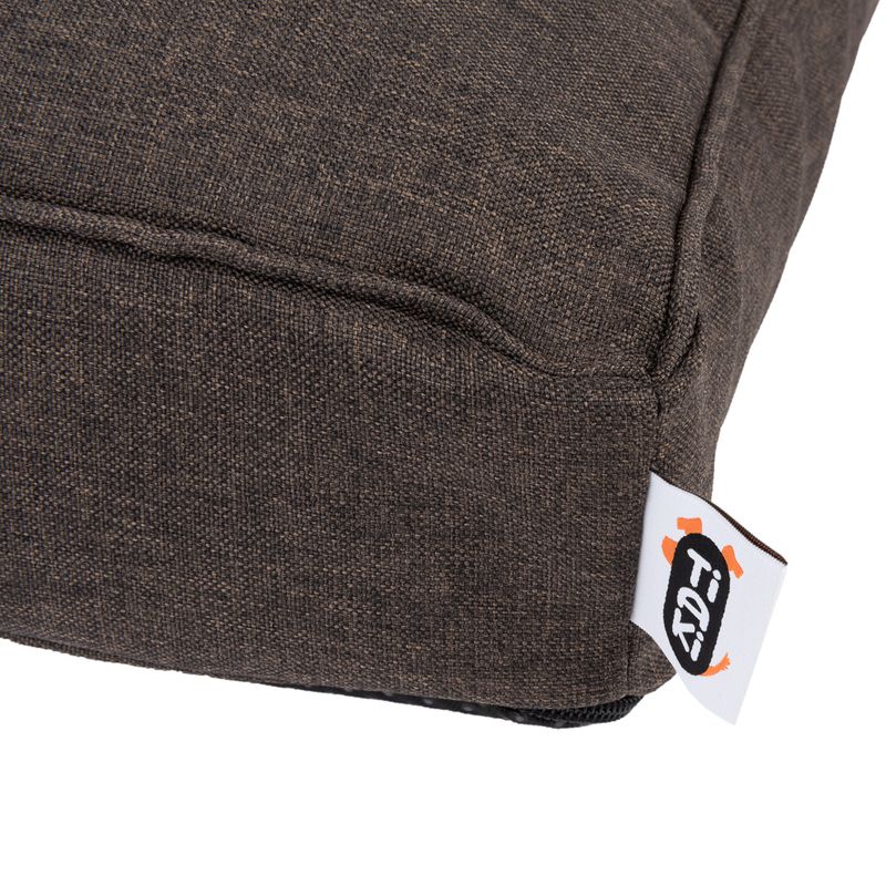 Close-up of a brown fabric cover with visible Trixie brand label.