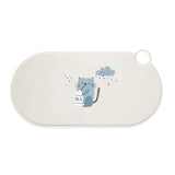 White oval mat with illustration of a grey cat drinking from a milk bottle. Stars and a cloud in the background.