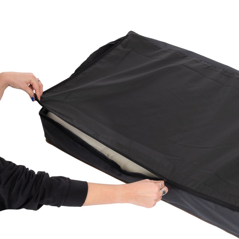 Hand opens black zip of a removable cover, visible is a cushion underneath.