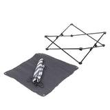 Foldable black frame, grey mat with eyelets, and folded striped fabric. Accessory for assembly or transport.