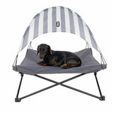 Dog lounger with grey fabric and striped sun canopy, brand TIAKI. Suitable for pets to relax in the shade.