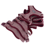 Several red-grey dog harnesses with herringbone pattern and adjustable buckles, stacked.