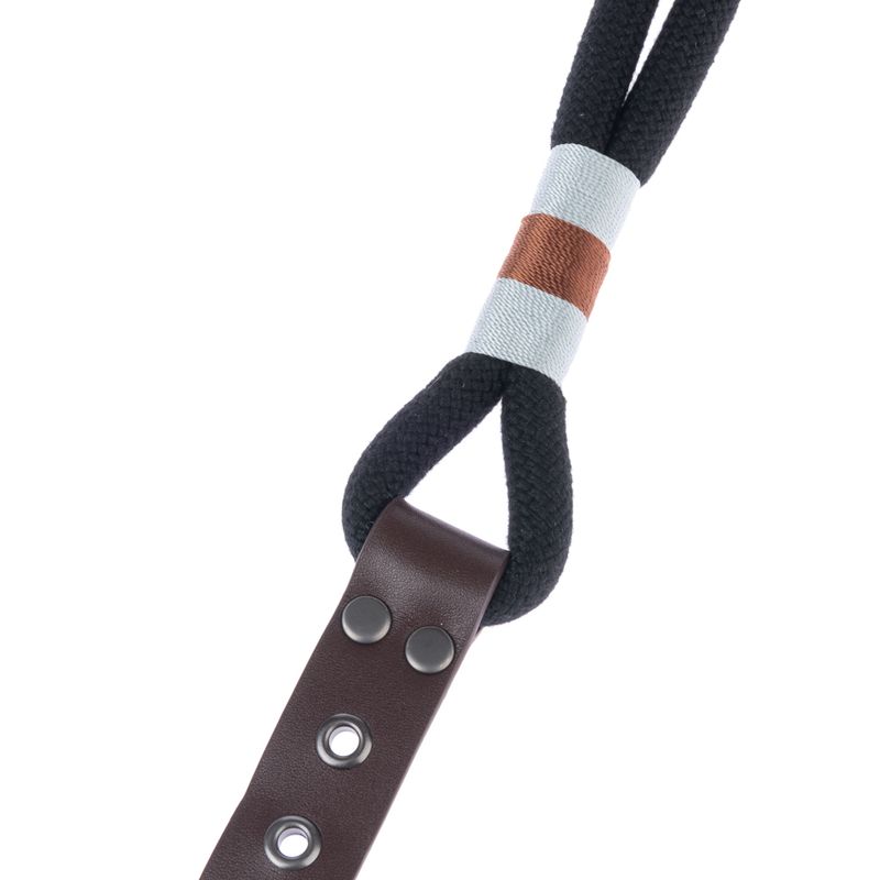 Close-up of a dog lead made of black rope with a brown leather handle and coloured wrapping in white and brown.