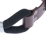 Close-up of a black rope with brown leather holder and silver studs.
