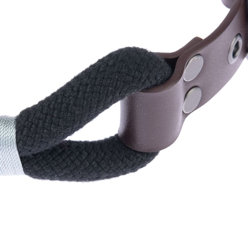 Close-up of a black rope with brown leather holder and silver studs.