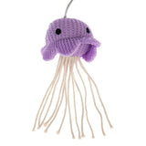 Purple crocheted toy in the shape of a jellyfish with long white threads as tentacles.