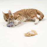 Red tomcat playing with a grey fabric toy shaped like an insect, next to a yellow fabric toy shaped like a fish.
