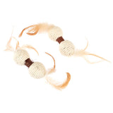 Toy made of sisal with two balls and brown feathers at the ends.