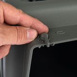 Hand showing how the grey locking mechanism of a transport box is opened or closed.